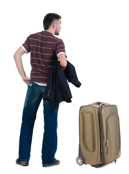 Young man traveling with suitcase looks ahead. Rear view. — Stock Photo, Image