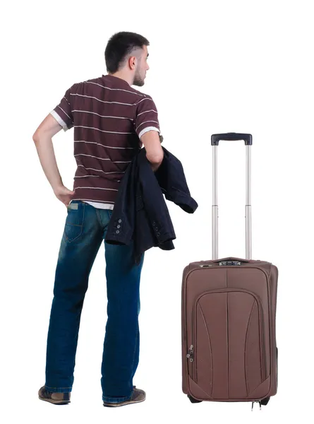 Young man traveling with suitcase looks ahead. Rear view. — Stock Photo, Image