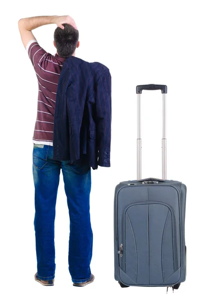 Young man traveling with suitcase looks ahead. Rear view. — Stock Photo, Image