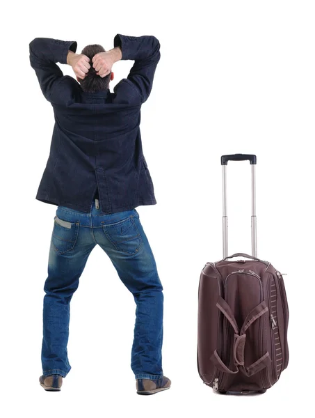 Сердитый молодой человек с чемоданом — стоковое фото