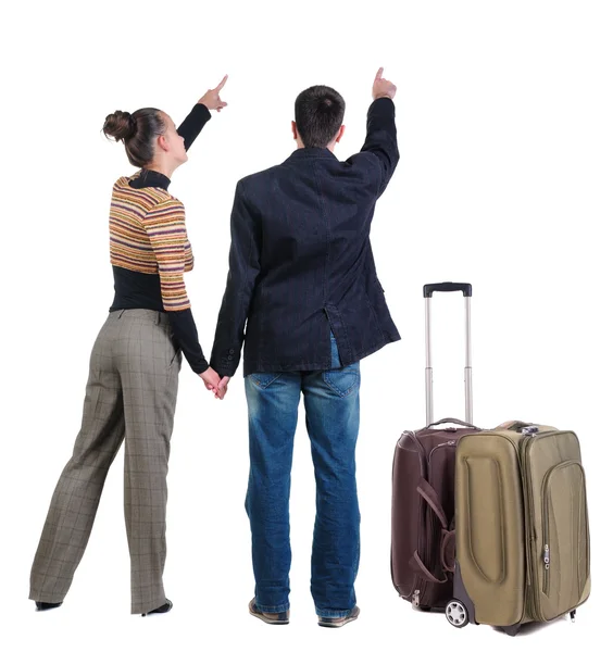 スーツケースと一緒に旅行若いカップルと壁を指して — ストック写真