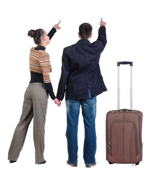 Jonge paar reizen met koffer en wijzend op de muur — Stockfoto