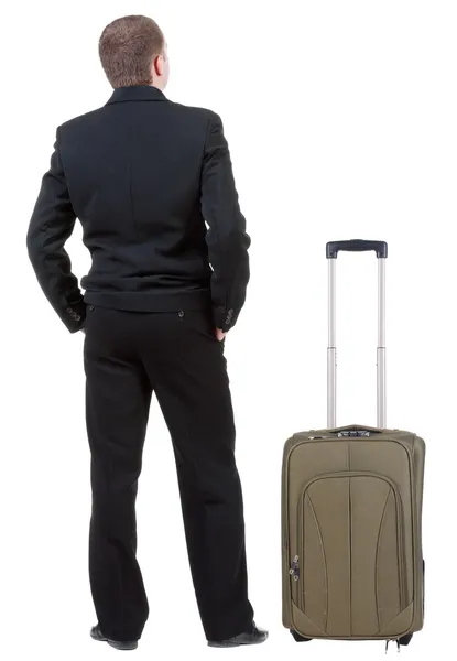 Back view of adult man in black suit traveling with suitcase. — Stock Photo, Image