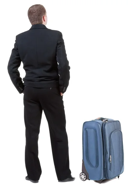 Back view of adult man in black suit traveling with suitcase. — Stock Photo, Image