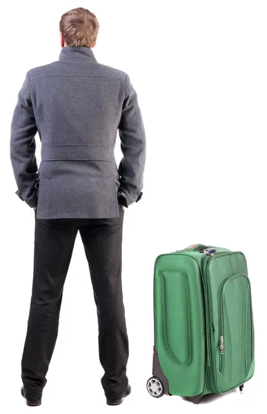 Powrót widok młody człowiek z walizką. — Zdjęcie stockowe