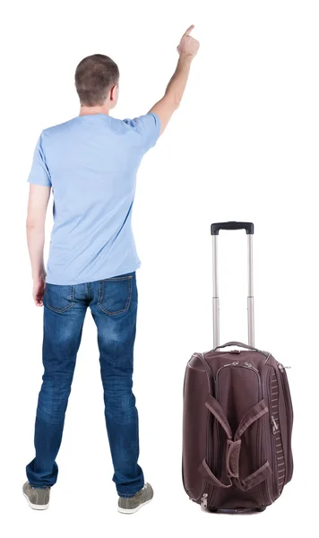 Back view of pointing young men traveling with suitcase. — Stock Photo, Image