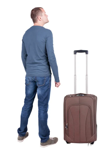 Powrót widok młody człowiek z walizką. — Zdjęcie stockowe