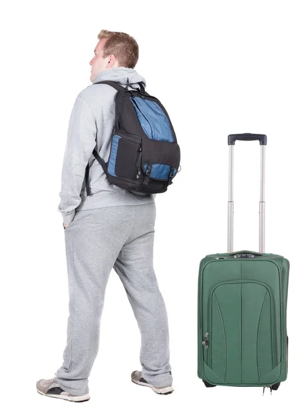 Back view of young man traveling with suitcase - Stock-foto