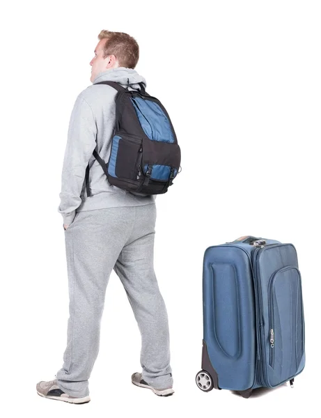 Back view of young man traveling with suitcase — Stock Photo, Image