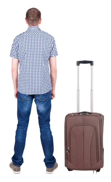 Back view of young man traveling with suitcase. – stockfoto