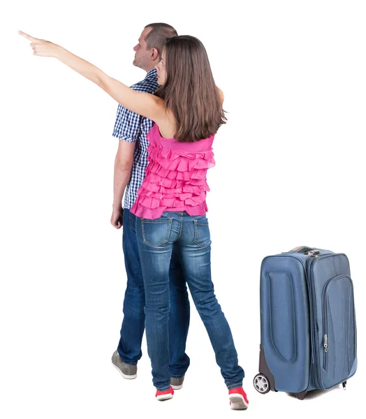 Jovem casal viajando com suitcas e apontando para a parede — Fotografia de Stock