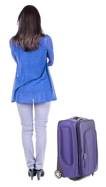 Achteraanzicht van staande jonge mooie brunette vrouw met koffer — Stockfoto
