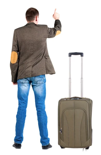 Powrót widok wskazując działalności człowieka w kurtkę z walizką — Zdjęcie stockowe