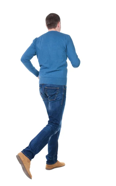 Pohled zezadu na běžící muž v modrém svetru. — Stock fotografie