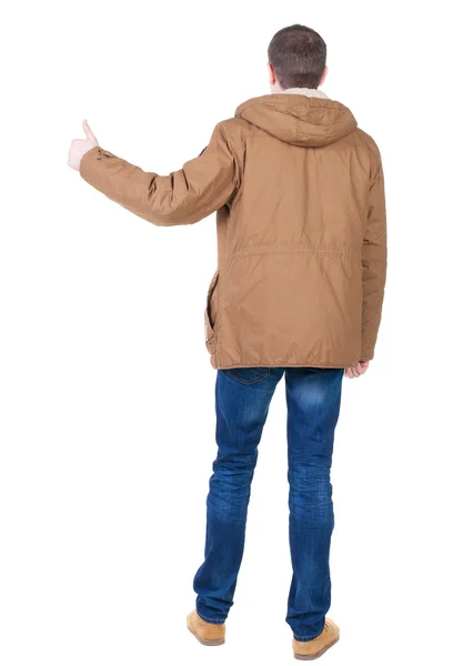 Vista traseira do homem bonito casaco de inverno mostra polegares. — Fotografia de Stock