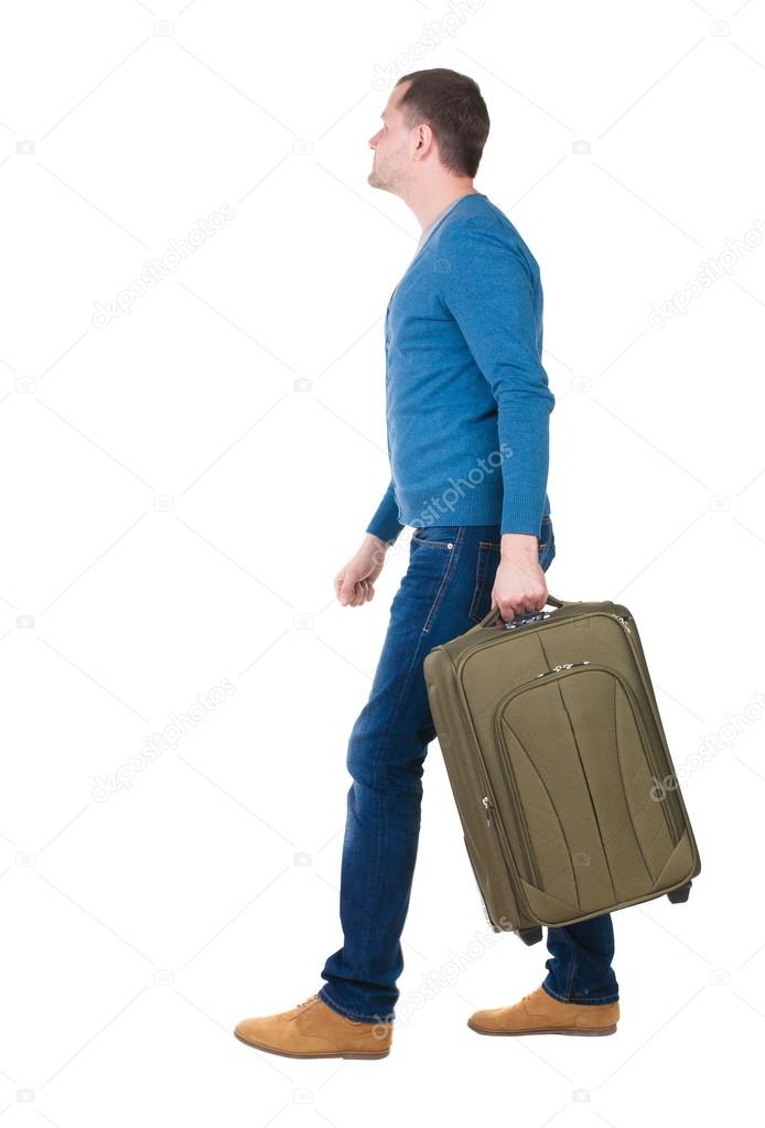 back view of walking man in pullover with suitcase.