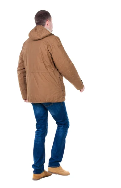 Hintere Ansicht gehen gut aussehender Mann in braun parka. — Stockfoto