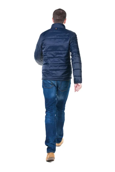 Bakifrån gå stilig man i jeans och jacka. — Stockfoto