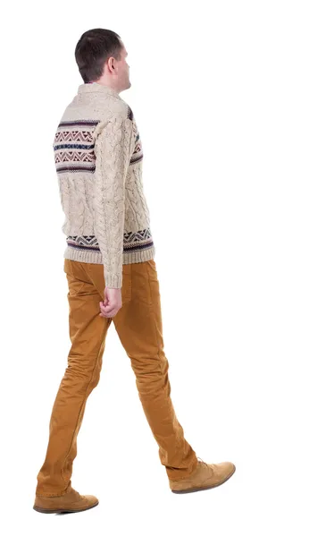 ハンサムな男のジーンズと暖かいセーターで行くの背面図. — ストック写真