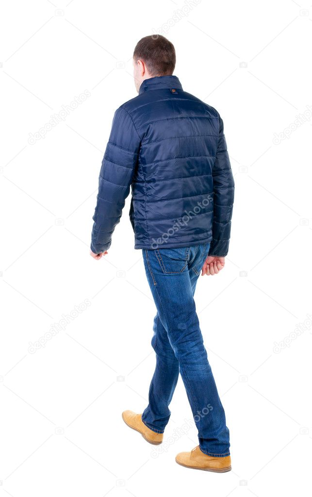 Back view of going handsome man in jeans and jacket.