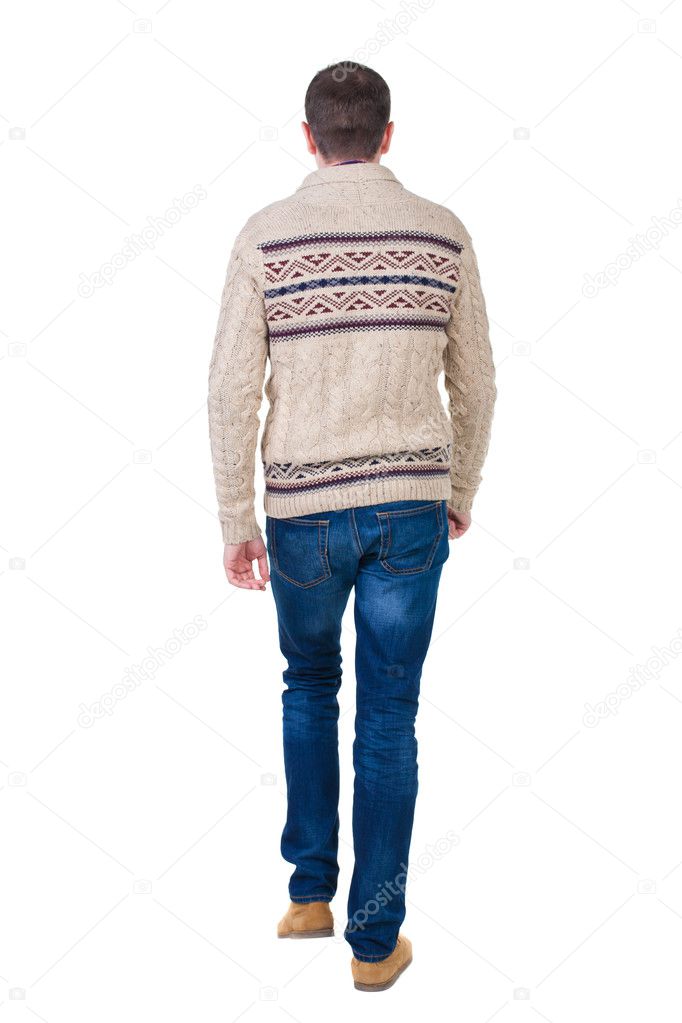 Back view of going handsome man in jeans and warm sweater.
