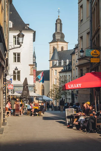 Lüksemburg / Nisan 2022: İnsanlar güneşli bir günde bar ve terasların keyfini çıkarıyorlar