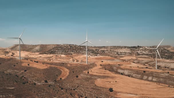 Moinhos de vento de grupo giram em campo deserto amarelo. Instalação de turbinas eólicas. Produção moderna de electricidade — Vídeo de Stock