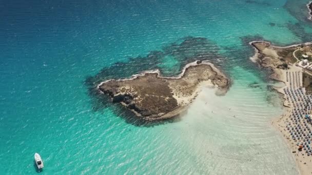Pulau berbatu yang terisolasi dikelilingi oleh perairan laut biru di pantai resor Ayia Napa di Siprus — Stok Video