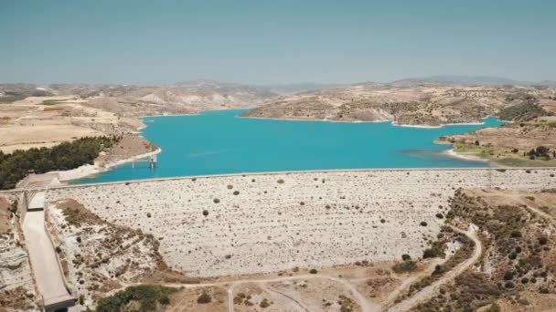 Réservoir de stockage d'eau de barrage dans le désert sec campagne de montagne de Chypre. Vue aérienne panoramique — Video