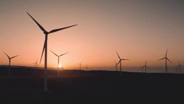 Turbine eoliche generano energia verde al tramonto nella zona di campagna suburbana. Lame del vento moderne — Video Stock