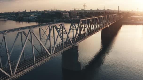 Ipari naplemente városkép. Vasúti híd lezárni a légi kilátást. Repülőgép repül a városközi vasút felett — Stock videók