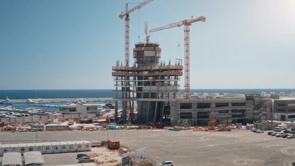 Guindastes altos trabalham na construção de novos edifícios. Paisagem arquitectónica. Desenvolvimento das infra-estruturas — Vídeo de Stock