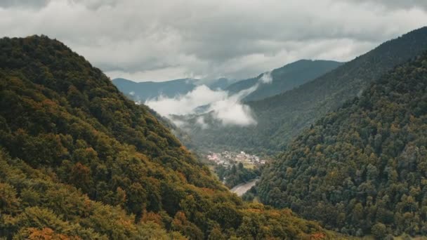 Verstecktes Alpendorf in Gebirgsschlucht. Dramatisch bewölkter Himmel in der Hochlandschlucht. Herbstwald — Stockvideo