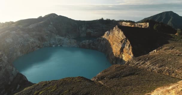 Letecké panorama sopečné kaldery, tyrkysového jezera a horských štítů. Divoká příroda východu slunce — Stock video