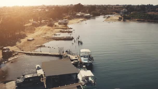 Halászhajók légi naplemente táj. Kis falu a folyó partján. Nyári vakáció szabadtéri turizmus — Stock videók