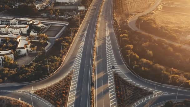 Bela vista aérea da estrada do por do sol. Drone voando sobre nova junção estrada de asfalto viaduto com carros — Vídeo de Stock