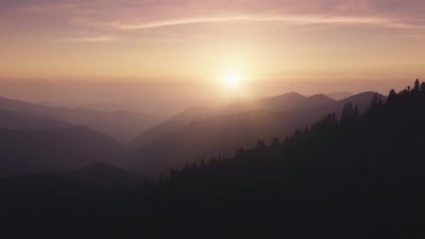 アルプスの山々での日没の空中撮影。山の峰、崖、尾根、明るいオレンジ色の空、雲 — ストック動画