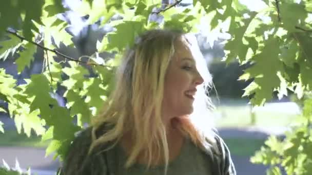 Sexy Frau entspannen. Das sonnige Laub der Bäume verzweigt sich im Park. Nahaufnahme Frühlingslandschaft. Körper positiv — Stockvideo