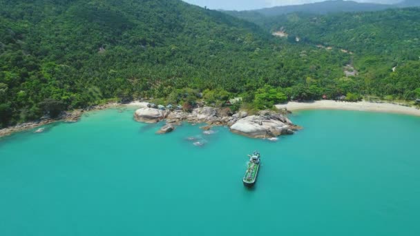 Thailands Meeresküste aus der Luft: Schiff in der Nähe eines riesigen Felsbrockens am weißen Sandstrand von Haad Thong Reng — Stockvideo