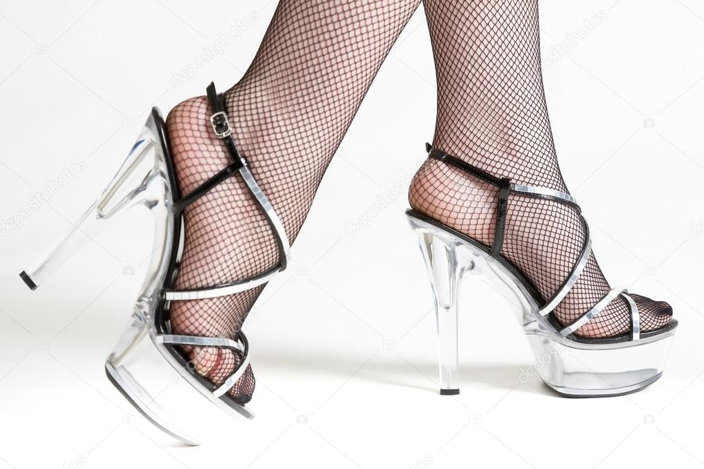 female legs in black stockings and transparent shoes