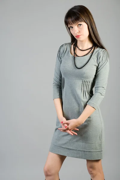 Fiatal nő, egy szürke ruhát — Stock Fotó
