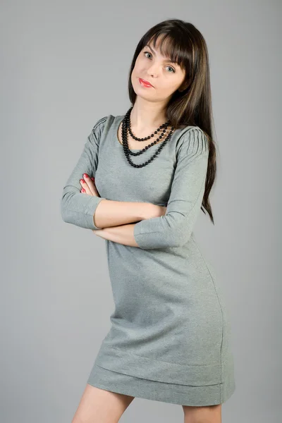 Junge Frau in einem grauen Kleid — Stockfoto