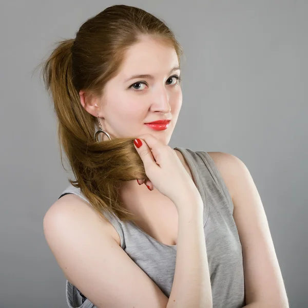 Menina com cabelos longos e uma blusa cinza — Fotografia de Stock