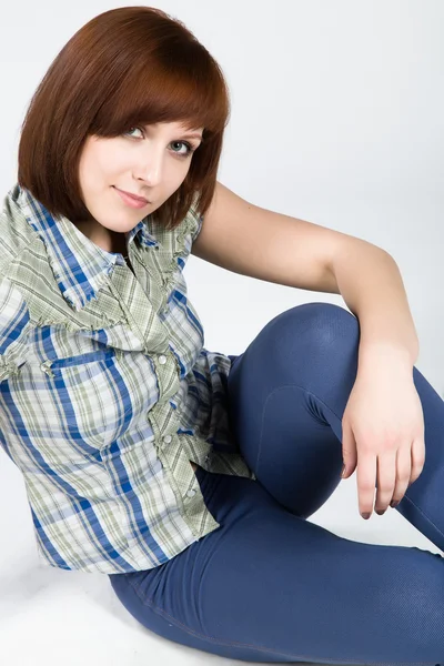 Young brunette in a plaid shirt — Stockfoto