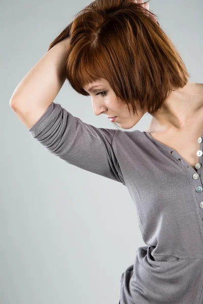 Mooie brunette in een grijze blouse — Stockfoto