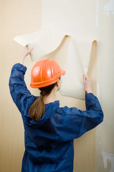 Trabalhador remove papel de parede velho — Fotografia de Stock