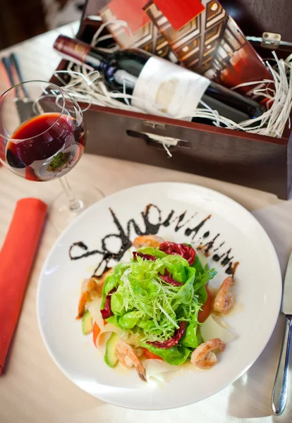 Zeevruchten salade en rode wijn — Stockfoto