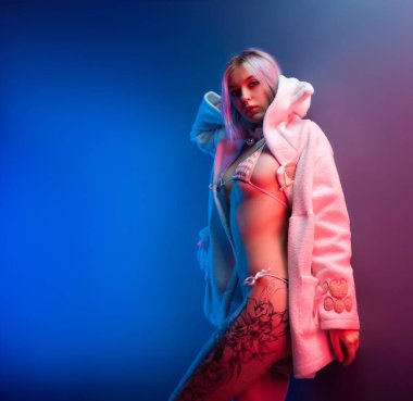 Güzel bir kapüşonlu seksi genç kız. Kulakları iç çamaşırlı, neon ışıklı.