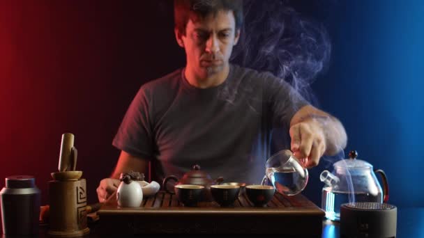 Ένας άνθρωπος κάνει τσάι σε ένα τραπέζι τσαγιού με συσκευές σύμφωνα με την παραδοσιακή κινεζική παράδοση — Αρχείο Βίντεο