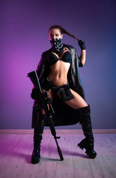 Sexy tueur féminin en sous-vêtements et un imperméable en cuir et de longues chaussures en cuir avec un fusil automatique m16 avec une vue télescopique — Photo